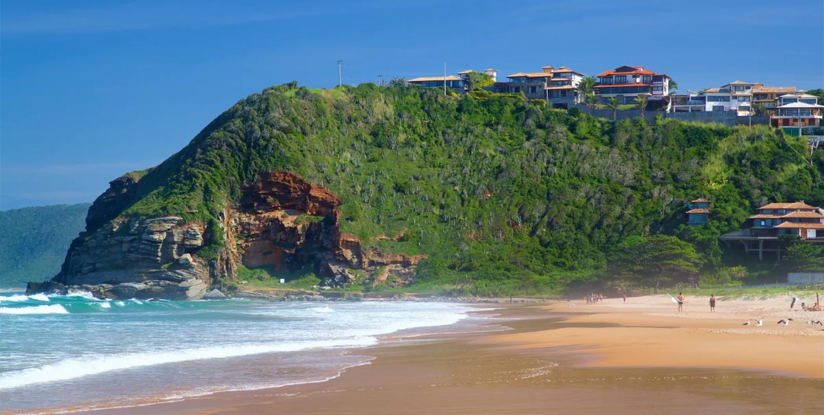 Praia de Geribá, com ondas e o morro coberto de vegetação ao fundo